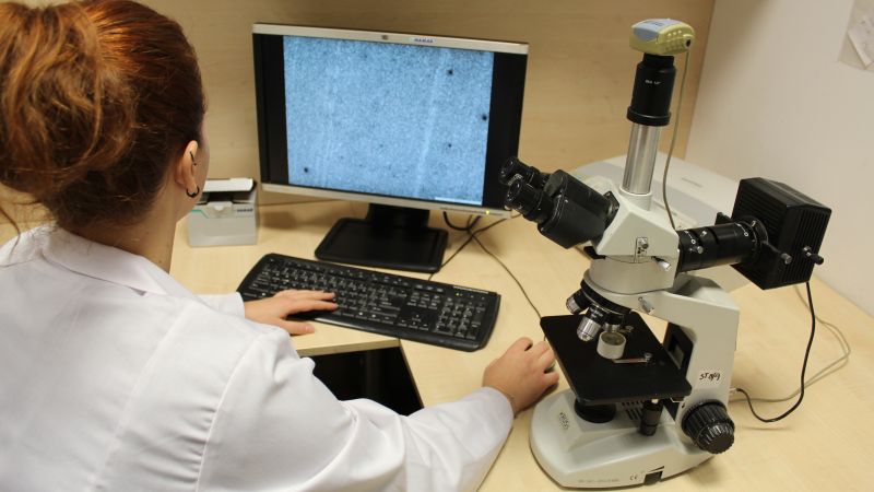pracownik kontrolujący jakość zamocowań przy monitorze i mikroskopie