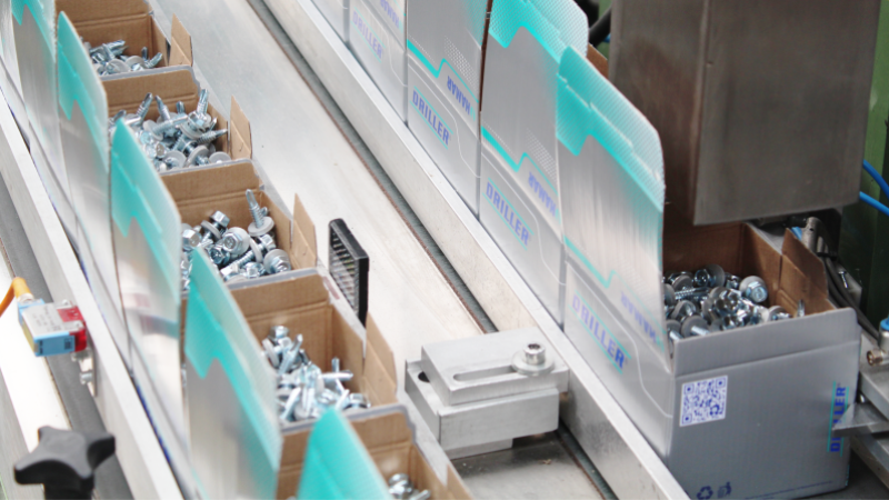 kartony z wkrętami samowiercącymi na linii produkcyjnej maszyny pakującej